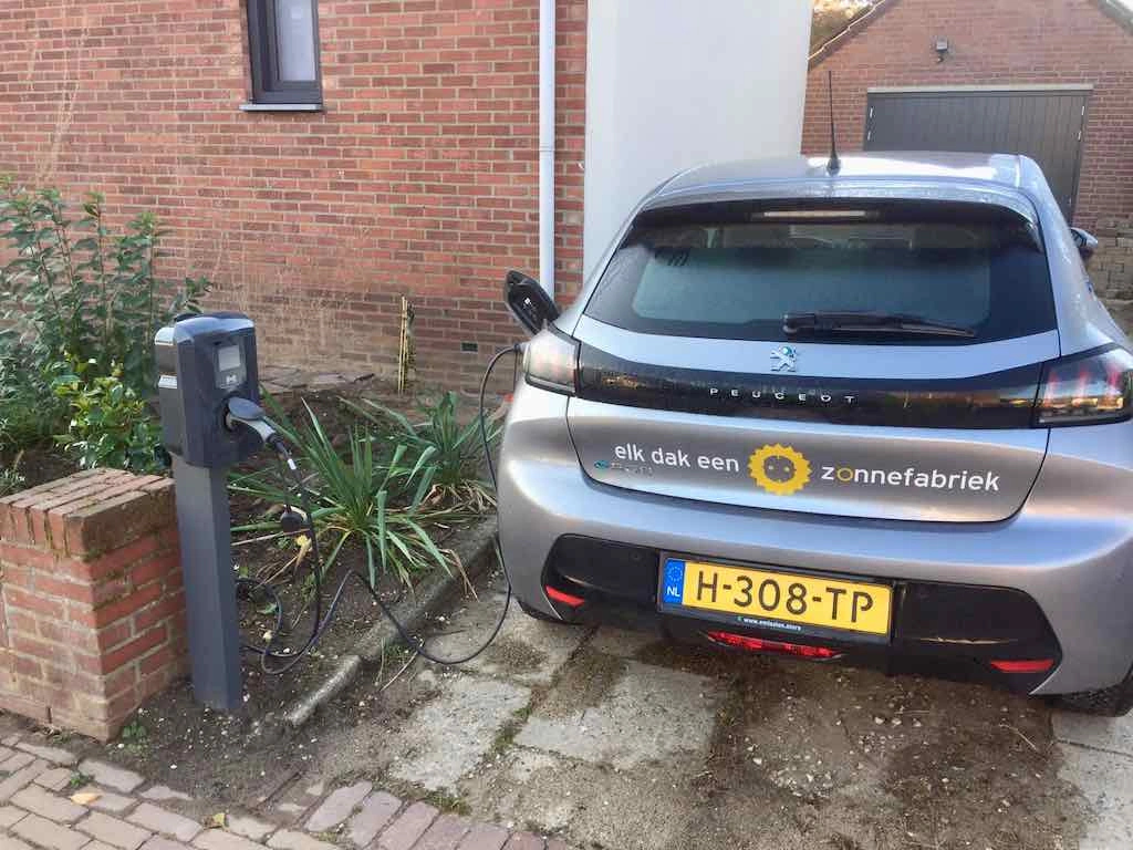 Elektrische auto van Zonnefabriek aan een standaard laadpaal